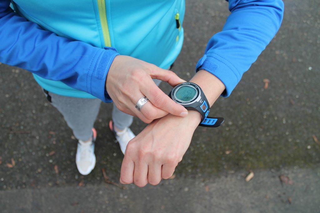 A runner looks at their sports watch.